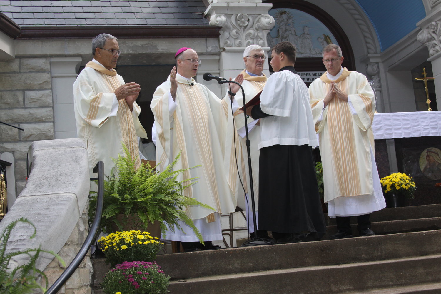 Bishop W. Shawn McKnight presides at the Mass at the outdoor altar on Sept. 11, for the annual Fall Pilgrimage to the Shrine of Our Lady of Sorrows in Starkenburg. Assisting him are Deacon Joseph Horton, Deacon Gerald Korman and Deacon Luke Mahsman. Pilgrimages to the shrine have been an annual event since 1891.